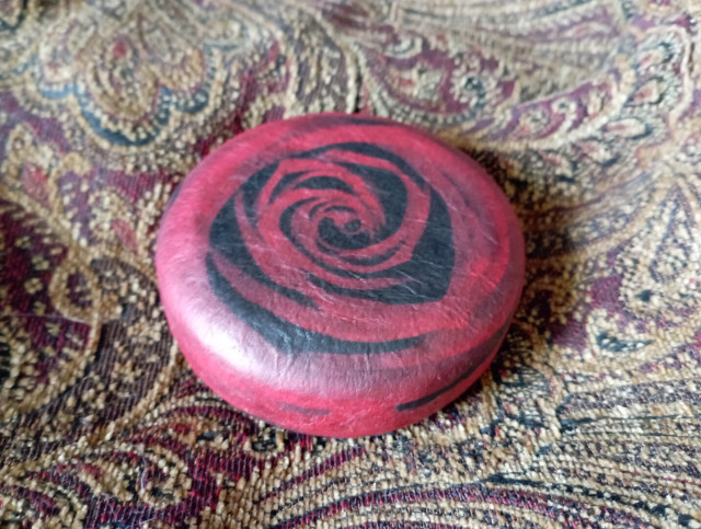 A closed round red box with a large rose printed on top. I used the centre of the print on a decorative napkin as the final paper layer on both top and bottom.