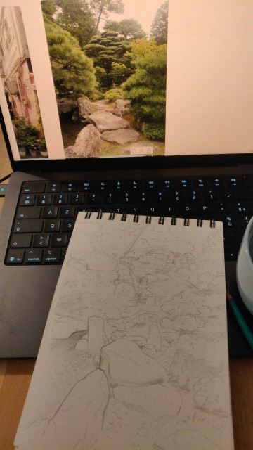 A sketch book laying down on a macbook. On the screen is a picture of a japanese garden, and on the sketchbook a pencil sketch trying to reproduce it. The amount of details is overwhelming.