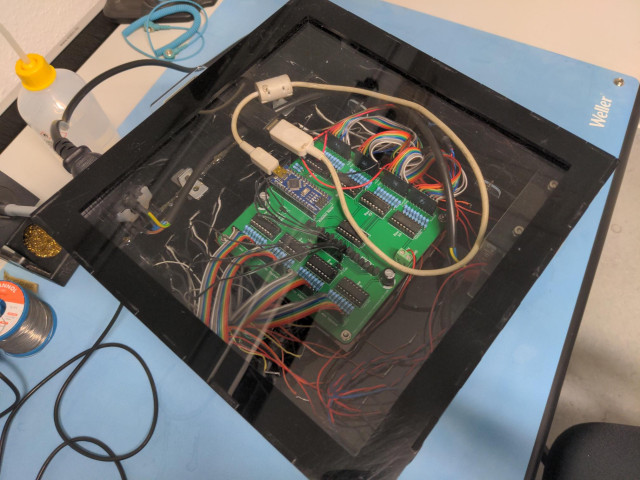 the bottom of the cube shows a transparent door which can be removed by sliding it out. through the transparent acrylic glass the PCB, Arduino nano and lots of rainbow cables are visible.