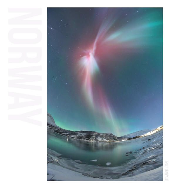 Like a galaxy unfolding above us, a corona bursts open above the fjord. The sky is washed with green light, but the high energy red filaments dominate the moment.