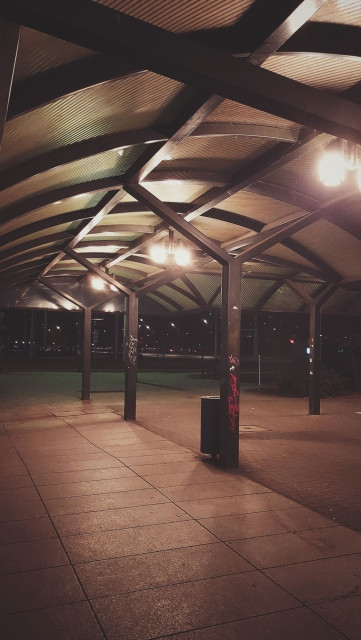Waiting area of a bus stop at night. No people.