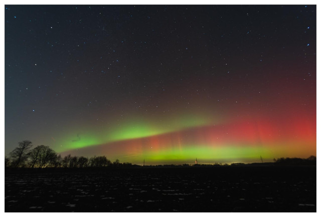 Polarlichter (rot/grün) im Nachthimmel.