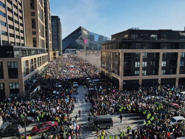 A picture of downtown Minneapolis, looking south toward US Bank Stadium. The streets teem with people as far as the eye can see. 