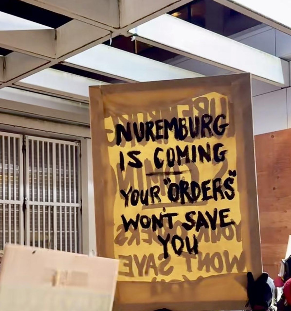 Sign “Nuremberg is coming your ”orders” won’t save you” 