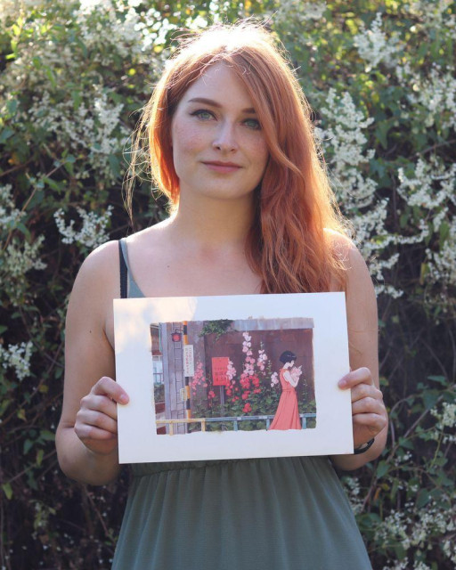artist holding original artwork