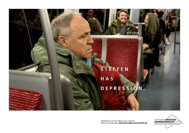 Advertisement about depression. In the photo you see a scene in public transport. A man with a unhappy face sits in the foreground. In the background you can see other people. A man and a woman are laughing.
Larger text at the man in foreground: Steffen has depression.
Small text at the laughing man in the background: This is Steffen.
Text at bottom of advertisement: Depression isn't at obvious as it seems.
Find out more here: deutsche-depressionshilfe.de
Logo with slogan of said organisation.