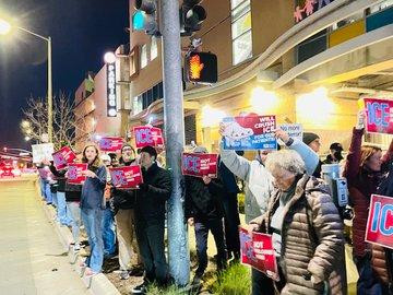 Crowds line the street holding placards