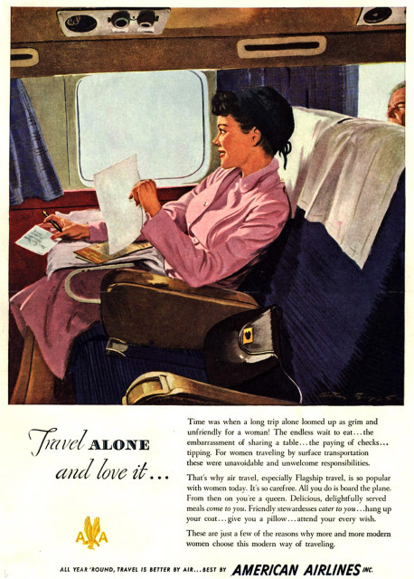 This is a full-page, illustrated color advertisement for American Airlines.

The main image shows the interior of an airplane cabin. A woman is seated alone in a wide, upholstered airline seat next to a window. She is wearing a pink dress and is smiling while reading a letter or document held in her hands. A pen, papers, and a small booklet or wallet rest on her lap or the seat tray area. The seat has a white cloth headrest cover, and a second passenger, an older man, is partially visible in the seat behind her. Overhead, small round air vents and light fixtures are visible above the window. The scene suggests a quiet, comfortable, first-class or premium seating environment.

Below the illustration is large headline text reading, “Travel ALONE and love it…”

To the right of the headline is a block of printed text describing air travel as convenient and comfortable for women traveling alone, emphasizing meals served at the seat, assistance from stewardesses, and freedom from inconveniences associated with surface travel.

At the bottom of the advertisement is the American Airlines logo, featuring an eagle emblem, and text stating: “ALL YEAR ’ROUND, TRAVEL IS BETTER BY AIR… BEST BY AMERICAN AIRLINES INC.”

The overall tone presents air travel as modern, comfortable, and especially appealing for solo women travelers.