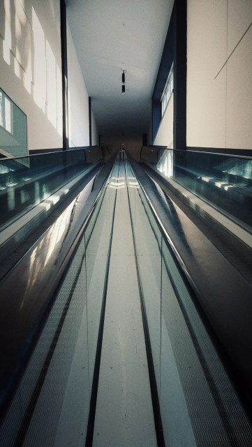 An empty rolling staircase in an empty mall.