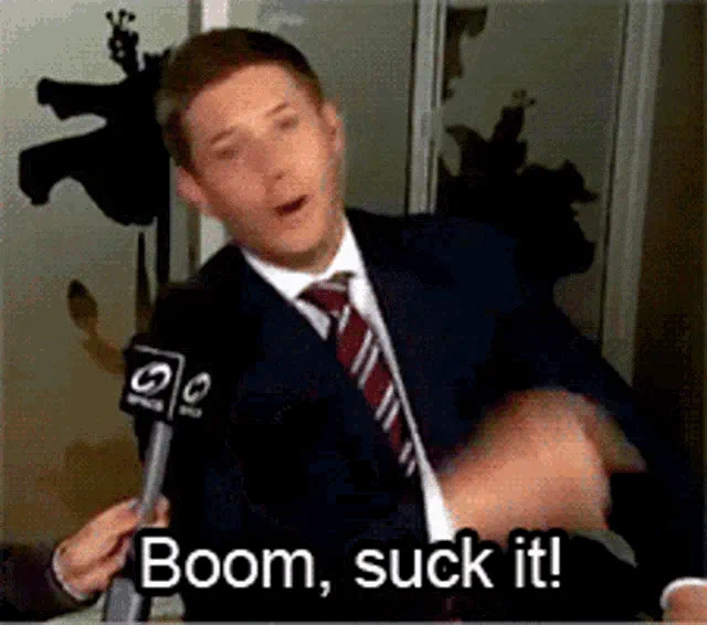 A Suited Man With A Microphone Saying 'boom Suck It' 