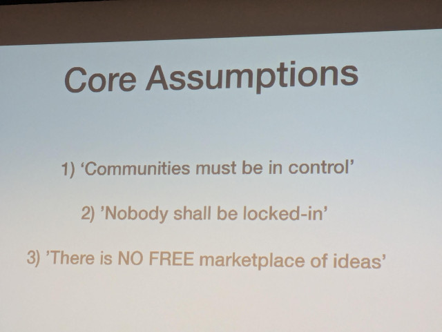 Slide titled "Core Assumptions" listing three points: 1) "Communities must be in control" 2) "Nobody shall be locked-in" 3) "There is NO FREE marketplace of ideas."