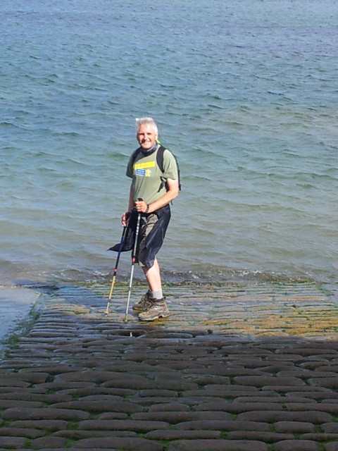 Three intrepid tether finishing his Coast to Coast walk by the sea in Robin Hoods Bay and a calm North Sea and a pleasant sunny day. 