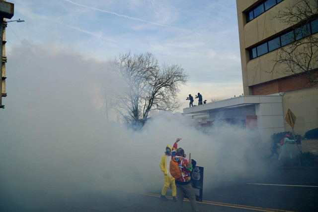 Two protesters in a cloud of teargas 