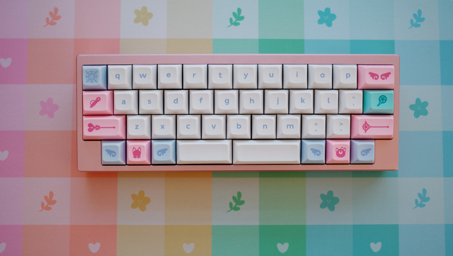 Pastel picnic themed deskmat in rainbow with a 40% mechanical keyboard on top.