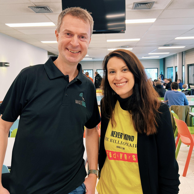 a photo taken in the FOSDEM cafeteria showing Daniel Stenberg on the left (he's wearing a black wolfSSL t-shirt) and me on the right, wearing a "never mind the billionaires, here's the fediverse" t-shirt