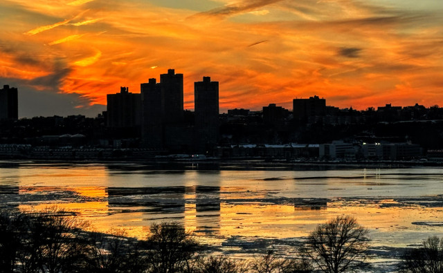Sunset colors reflect off ice floating in the Hudson River in NYC.