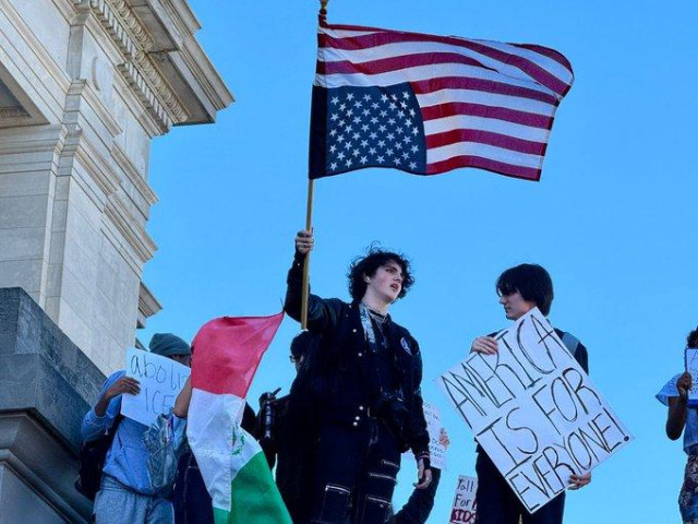 Two high schoolers at a protest in Little Rock.  One is holding a placard reading AMERICA IS FOR EVERYONE