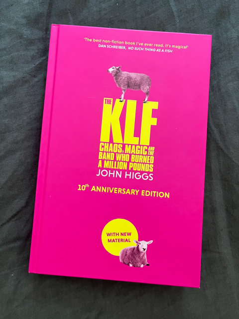 'The KLF: Chaos, Magic, and the Band Who Burned a Million Pounds' by John Higgs. Pink hardcover book with yellow text and two photographs of sheep.