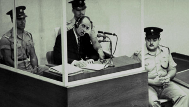 A famous 1961 photo of Adolf Eichmann on trial in Jerusalem; Eichmann's face has been replaced with the face of Stephen Miller.

Image:
Gage Skidmore
https://commons.wikimedia.org/wiki/File:2025_-_Stephen_Miller_(cropped).jpg

CC BY-SA 3.0
https://creativecommons.org/licenses/by-sa/3.0/deed.en