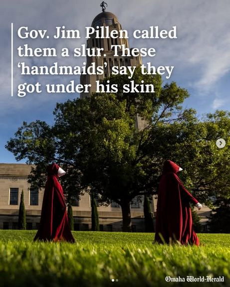 From the Omaha World Herald, two women are walking along a grassy area outside the Nebraska state capitol building. Text reads "Gov Jim Pillen called them a slur. These 'handmaids' say they got under his skin."