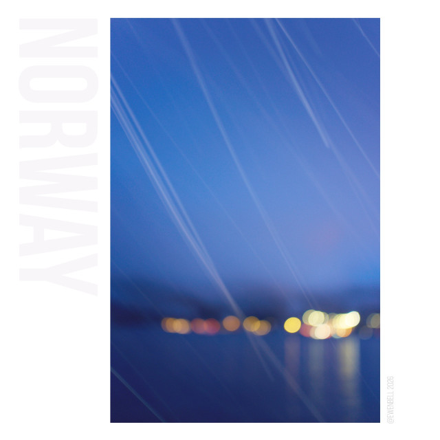 A very blue hour with the distant lights ballooning in the background while the focus is trained close-in to catch the snow flakes.