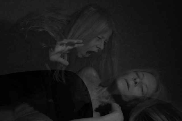 An image of a woman laying in bed with a peaceful expression on her face. Above is another woman looking mad and angry, as if she is on her way to disturbe the sleeping person with a nightmare. 