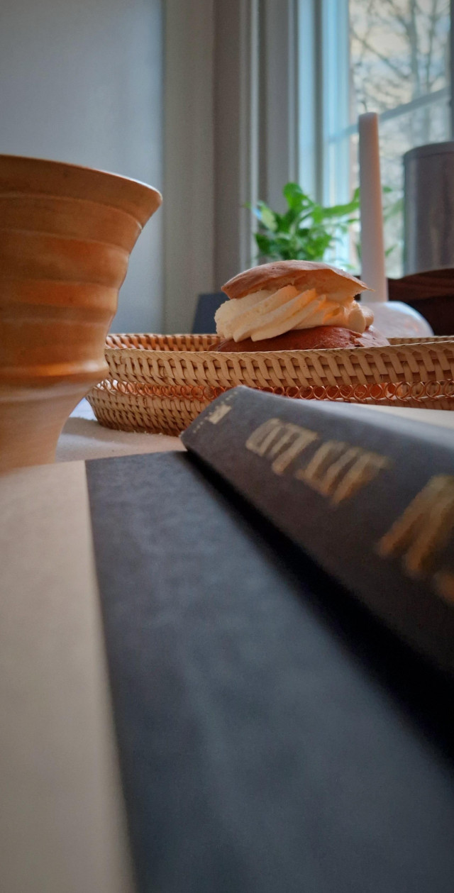 Semla, bok och kaffemugg.