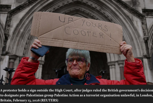
A protester holds a sign outside the High Court, after judges ruled the British government’s decision
to designate pro-Palestinian group Palestine Action as a terrorist organisation unlawful, in London,
Britain, February 13, 2026 (REUTERS)
