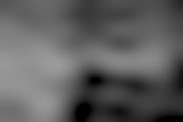 A gable of a house and part of a chimney at the low right side. Above a sunny sky with a lot of feather-like clouds. 