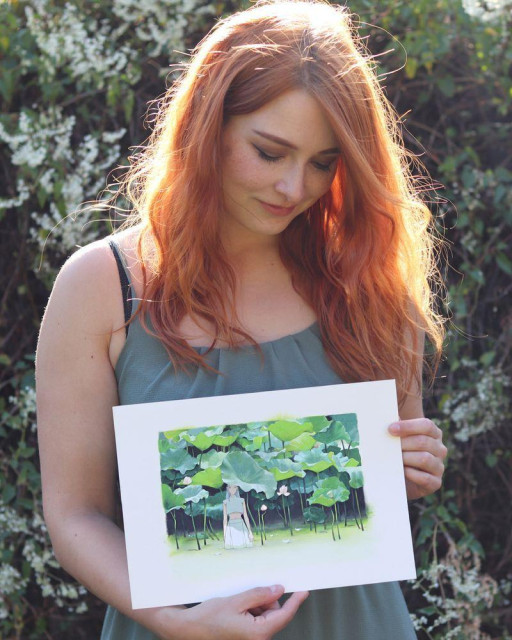 a photo of an artist holding an original painting
