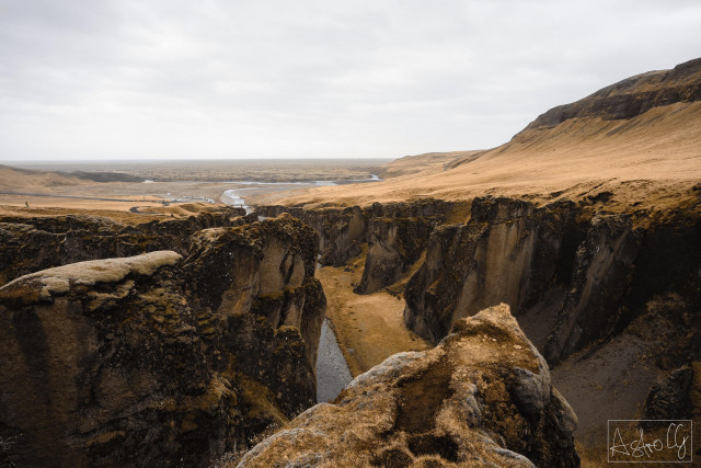 Rocky canyon with steep walls and a river winding through a vast, barren landscape