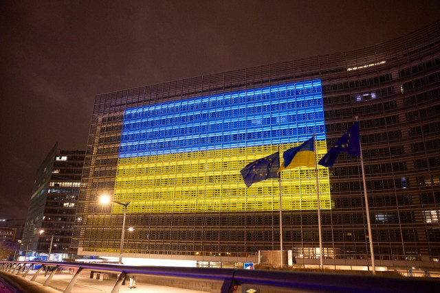 A photo of a building, the European Commission's headquarters, illuminated with the colours of the Ukrainian flag.