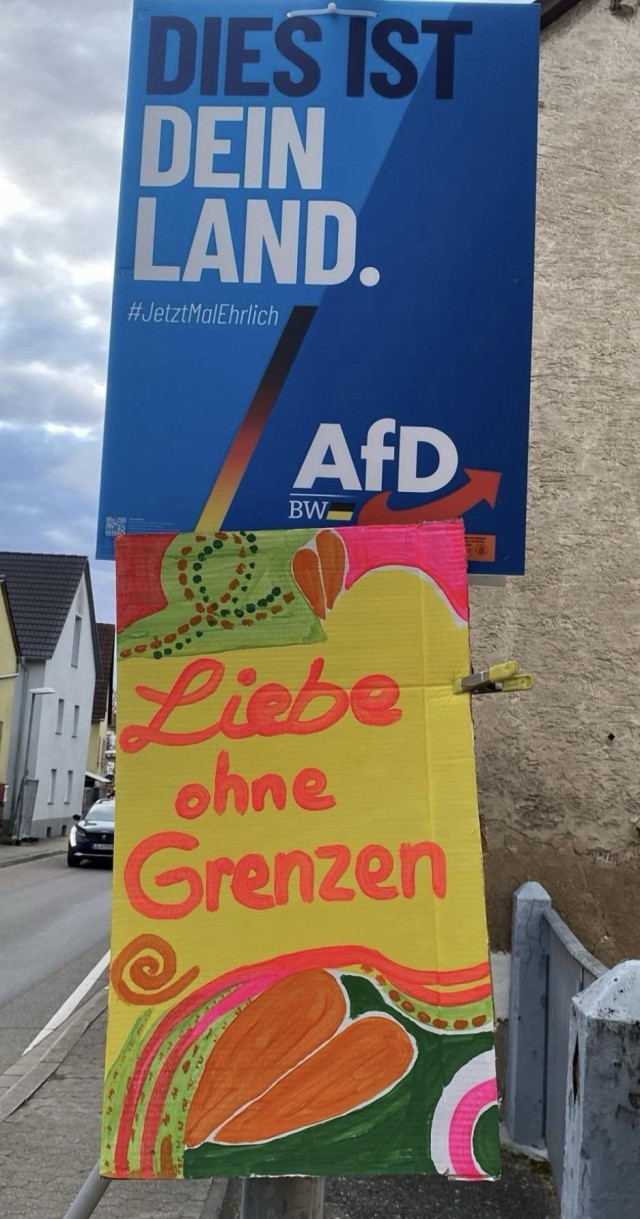 Blaues Plakat und Gegenplakat:  dies ist dein Land ... Liebe ohne Grenzen