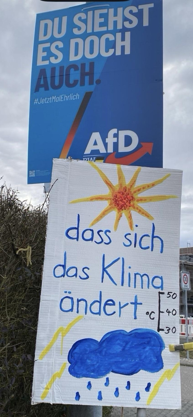 Blaues Plakat und Gegenplakat:  du siehst es doch auch ... dass sich das Klima ändert 