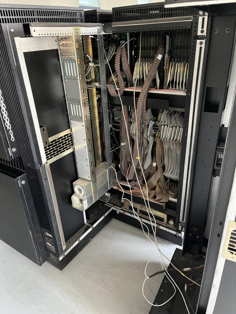 View into the inside of a Connection Machine. One of the four cabinets has been opened and slid to the side. In the center many cables can be seen.