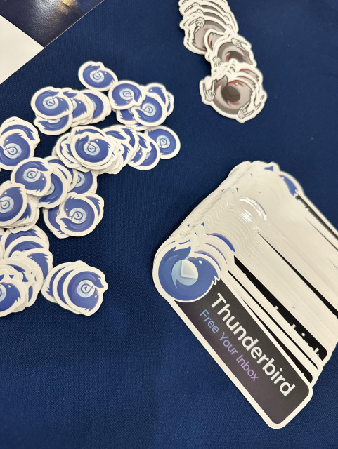 A collection of Thunderbird stickers on a blue tablecloth