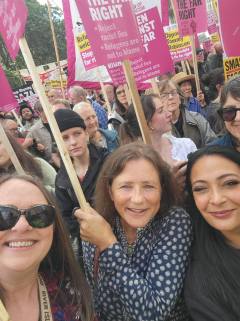 A collection of women holding signs saying "women against the far right"