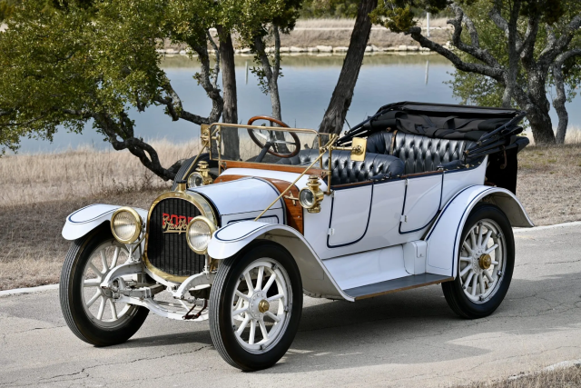 This 1913 Pope-Hartford Model 31 is a four-passenger phaeton that is said to have spent several decades in California, where it was purchased by the father of its previous owner in the 1990s. Wearing an older refurbishment, the car is said to have participated in Horseless Carriage Club tours over the years before being purchased by its current owner approximately a month ago. Power is provided by a 300ci inline-four with two monobloc cylinder and head castings, overhead valves operated by cold-drawn steel-tube pushrods, and a mechanical oiling unit. Finished in white, the car also features a four-speed manual transmission, rear drum brakes, 27” wood-spoke wheels with demountable rims, a black convertible top, black tufted leather upholstery over two rows of bench seating, and a rear luggage rack carrying a wicker basket.