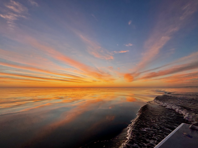 Sunrise on the Chesapeake bay reflections of orange and yellow in the water 