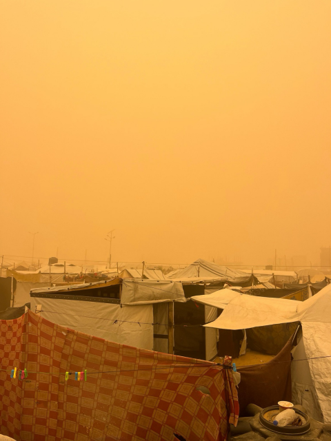 A strong sandstorm is hitting the area. Many tents have been blown away, and palm trees have fallen onto the tents of displaced people, causing injuries to some of them.