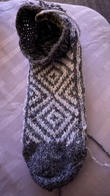 a sock knit in two shades of grey with a dark toe and a stranded diamond pattern for the rest, view of outside 