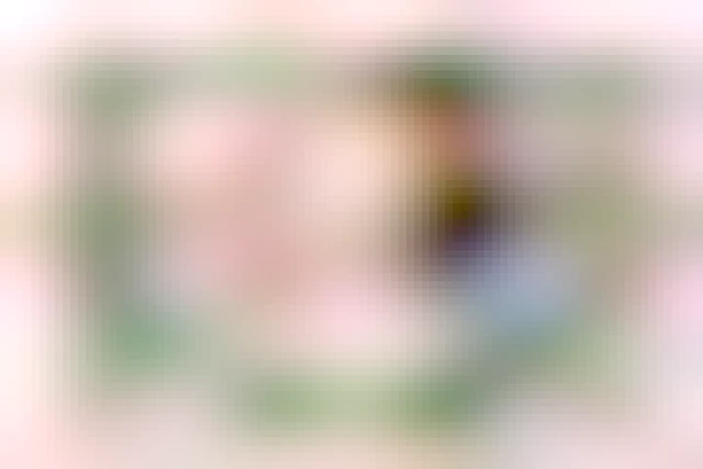 A digital illustration of my OCs Owen and Katie for valentines day.
They are arranged as half-body side views looking at each other, framed by a heart of light pink climbing roses.

He wears a strawberry icecream pink turtleneck sweater tucked into grey high waist jeans, she wears a black t-shirt and light blue jeans.

They are exchanging a sword for her and a flower crown of pink roses for him as a nod to their twisted gender norms and adoration of the other as they are.