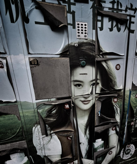 The face of a famous female star emblazoned on some locker boxes. The photography is peeling away around the box edges.