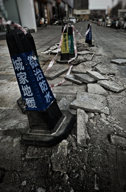 Bollards guarding some broken pavement.