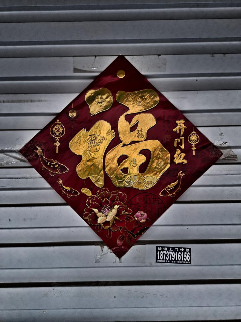 Chinese New Year decoration taped to a metal shutter.