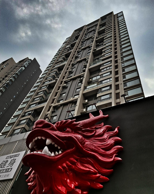 A tall building with a giant, red dragon's head at its base.