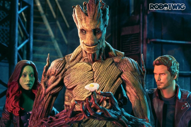 Groot grows a flower from his hand. Gamorra and Star lord look on