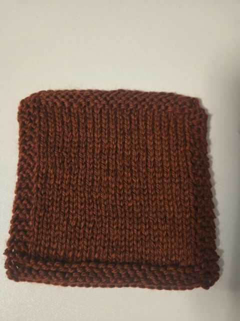 A knit swatch of Cascade 220 in the color Japanese Maple ( a reddish brown color)