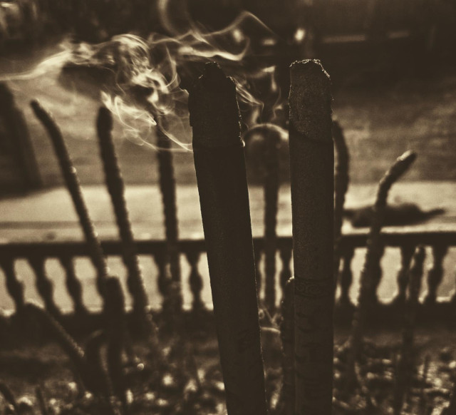 Incense burning in warm light outside temple