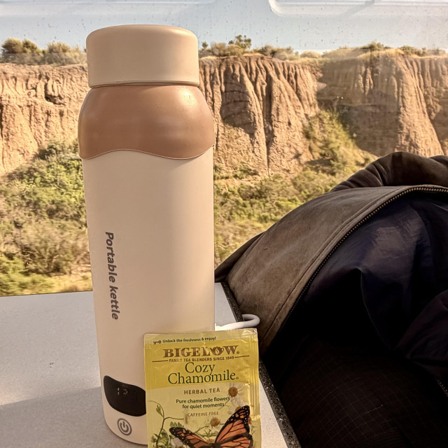 A photo of a water bottle shaped tea kettle and chamomile tea bag 